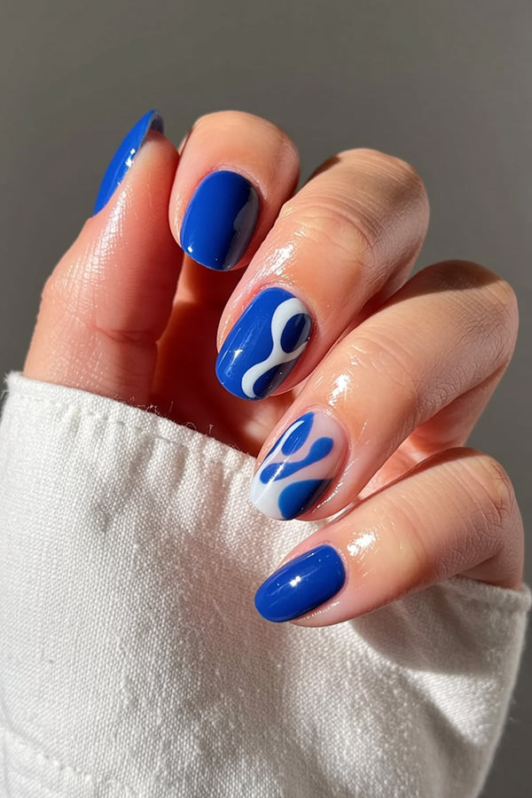 38 Bright cobalt blue nails with abstract white brushstroke art and negative space_bp